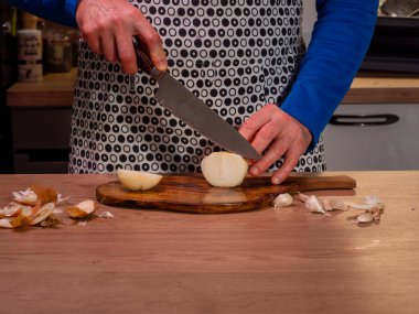 Aşçı odun kesme tahtasıyla soğan doğruyor. Yakın çekim..