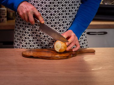 Aşçı odun kesme tahtasıyla soğan doğruyor. Yakın çekim..