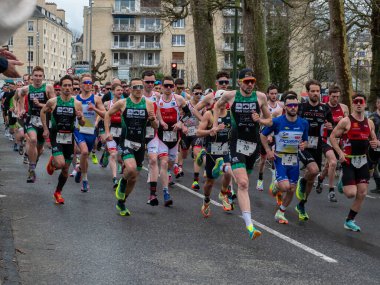 Caen, Fransa 2023. Triatlon müsabakaları, Fransa 'nın kuzeyindeki Caen şehrinde, Normandiya' da atletler bir grupta koşuyorlar.