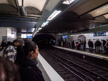 Paris, Fransa, 19 Nisan 2024: Paris Surlferino metro istasyonu, metro istasyonunda bekleyen insanlar, istasyona gelen tren, tünel ışıkları, EnrouteFrance