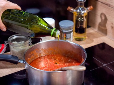 Domates sosuna zeytin yağı, İtalyan mutfağı, ev yemeği, metal kap ve ahşap kaşık.