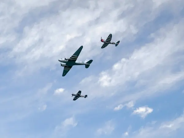 stock image Normandy, France - June 8, 2024: DC3 transport aircraft escorted by a World War II Spitfire P-47 flying in combat formation at the Arromanches Air Show, 80th D-Day celebration, Normandy