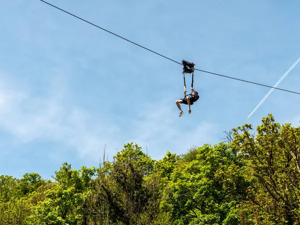 stock image Clecy, Normandy, France, May 10, 2024. Rappelling down the mountain extreme sports, one person in a helmet. Photo from below. Cleacy in Normandy, blue sky