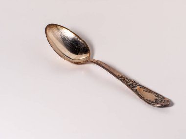 old silver tea spoon lies on a white background clipart