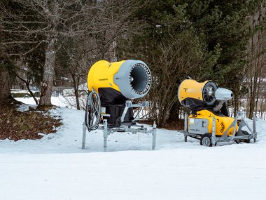 Chamonix, Fransa 23 Ocak 2025. Ağaçlarla çevrili karla kaplı bir arazide bir kar silahı duruyor. Bu cihaz kayak pistlerinde kar üretmek için yapay olarak kullanılır.