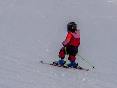 Chamonix, Fransa 19 Ocak 2025. 5-7 yaşlarında kayak yapan bir çocuk kayak pistinden aşağı iniyor, arkadaki Chamonix Alps France 'tan fotoğraf.
