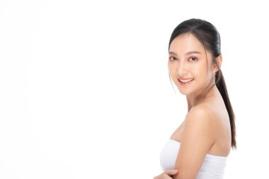 Güzel Asyalı kadının kameraya bakışını temiz ve taze tenli gülüşünü mutlu ve neşeli, olumlu duygusal, beyaz arka planda soyutlanmış, Güzellik ve Kozmetik Konsepti