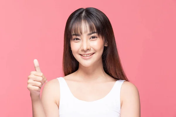 美しい魅力的なアジアの若い女性の笑顔と良いサイン親指を作るので 幸せと自信を感じます ピンクの背景に隔離 美容コンセプト — ストック写真