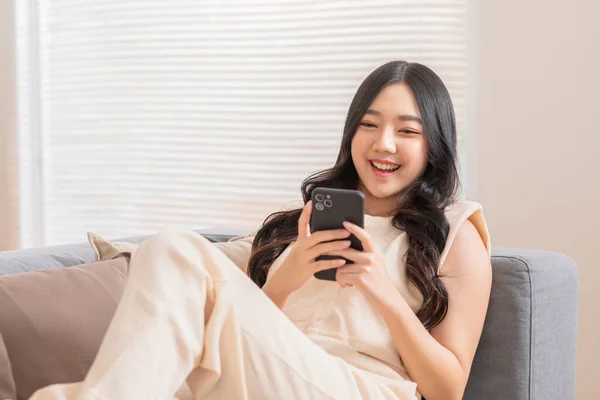 Wanita Muda Asia Yang Bahagia Tersenyum Menggunakan Telepon Pintar Berselancar — Stok Foto
