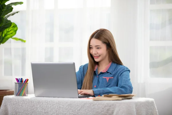 美しいアジアの若い女性は ソーシャルメディアと楽しまコンピュータラップトップを使用してソファの上にカジュアルシートを着用笑顔と笑いをリラックスします 自宅でオンラインショッピング — ストック写真