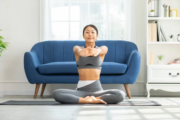 自宅でヨガで呼吸や瞑想を暖めるために筋肉を伸ばしスポーツウェアでアジアの女性の穏やかな 健康的な女性ヨガをやってとても快適でリラックスした ウェルネスヨガヘルスケアコンセプト — ストック写真
