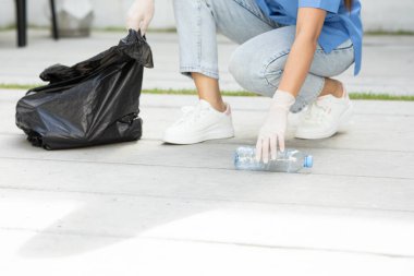 Gönüllü kadın, dünyayı kurtarmak için çöp poşetine plastik şişeler doldurup şehri temizliyor. Gezegendeki plastik kirliliği sorunu. Temizlik günü veya Dünya çevresi konsepti
