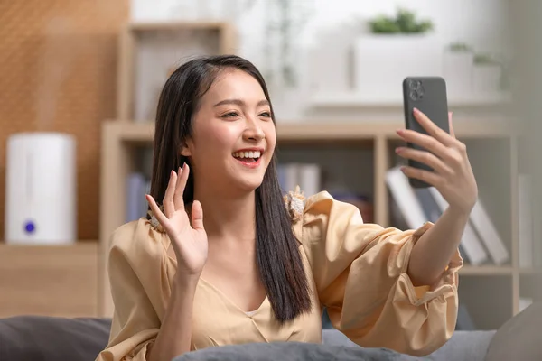 家庭でのビデオ会議コールを介してビジネスチームとのアジアの若い女性会議 オンラインビデオ通話で家族グループとの挨拶を手に入れます ビデオ通話で友人と話す積極的な若い実業家 — ストック写真