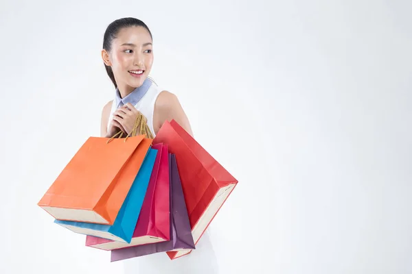 美丽迷人的亚洲女人微笑着 提着购物袋 在白色背景的购物中心里享受着黑色星期五的购物 购物生活方式概念 — 图库照片