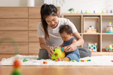 Asian mom teaching baby boy learning and playing toys for development skill at home or nursery room. Happiness mother and baby spending time together at warmth place. Good moment with mom and baby