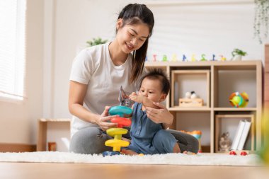 Asian mom teaching baby boy learning and playing toys for development skill at home or nursery room. Happiness mother and baby spending time together at warmth place. Good moment with mom and baby
