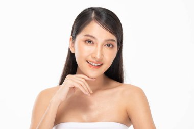Güzel Asyalı kadın yumuşak yanaklı gülüşüne dokunuyor temiz ve taze tenli mutlu ve neşeli, olumlu duygusal, beyaz arka planda soyutlanmış, güzellik kozmetiği ve kaplıca yüz bakımı kavramı