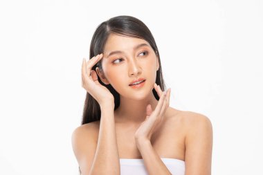 Güzel Asyalı kadın yumuşak yanaklı gülüşüne dokunuyor temiz ve taze tenli mutlu ve neşeli, olumlu duygusal, beyaz arka planda soyutlanmış, güzellik kozmetiği ve kaplıca yüz bakımı kavramı