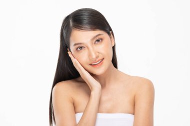 Güzel Asyalı kadın yumuşak yanaklı gülüşüne dokunuyor temiz ve taze tenli mutlu ve neşeli, olumlu duygusal, beyaz arka planda soyutlanmış, güzellik kozmetiği ve kaplıca yüz bakımı kavramı