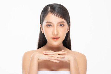 Güzel Asyalı kadın yumuşak yanaklı gülüşüne dokunuyor temiz ve taze tenli mutlu ve neşeli, olumlu duygusal, beyaz arka planda soyutlanmış, güzellik kozmetiği ve kaplıca yüz bakımı kavramı