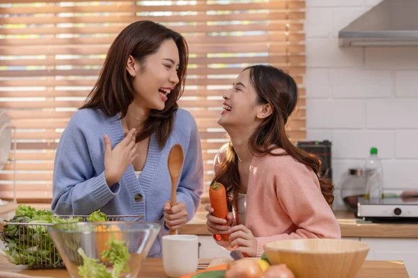 Birkaç LGBTQ aşığı mutfakta birlikte yemek pişiriyor gülümsüyor ve gülüyor. Mutluluk ve evde geçirilen hassas anlar. LGBTQ + Konsepti