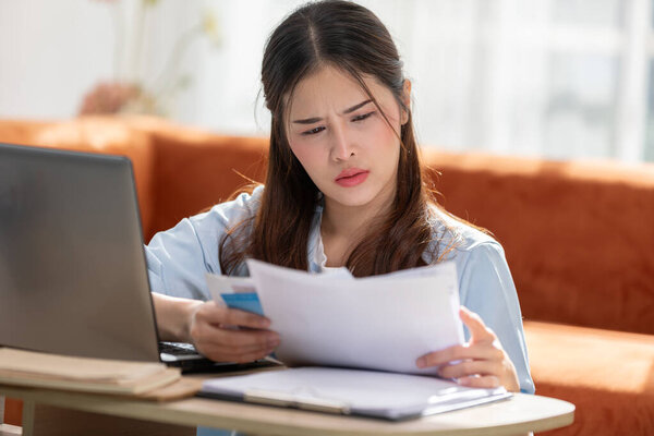 Young Asian Woman Looks Stressed While Examining Bill Impactful Financial Stock Picture