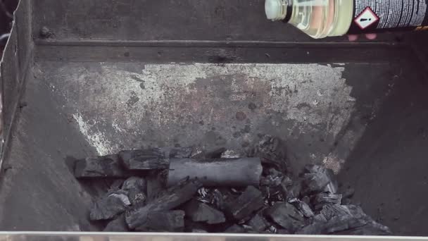 一种易燃的液体被倒在煤上用于烧烤 女人的手捧着一壶液体 在篝火中预演烹饪 — 图库视频影像