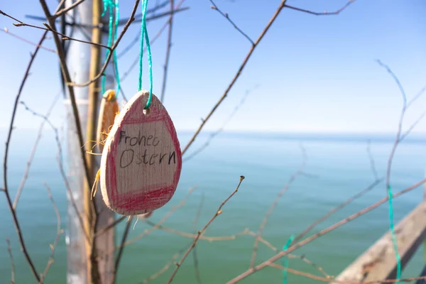 Dallara asılı bir Paskalya yumurtası modeli, denizin arka planı. Çocukların yaratıcılığı. Mutlu Paskalyalar