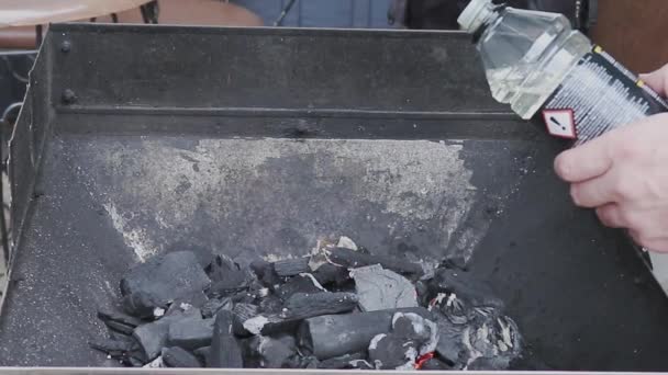 点火のための可燃性液体はグリルで開かれた火の上に置かれる バーベキューの準備 熱い石炭が燃えている — ストック動画
