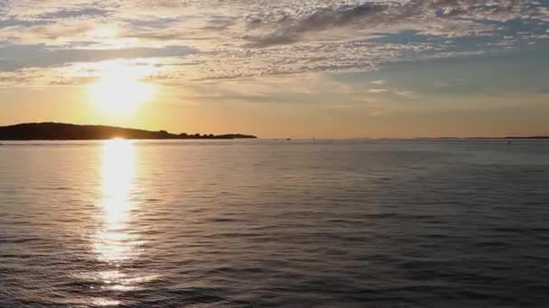 夕日の背景に対して海面上を飛ぶカモメのいくつかのシルエット 太陽の列は明るく輝いています 夜の海で — ストック動画