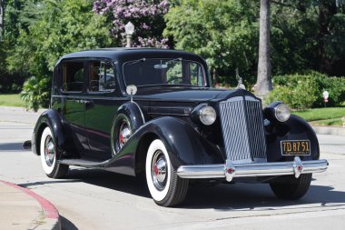 1930 'ların Packard otomobili güneşli bir öğleden sonra konut alanında araba sürerken görüldü. 27 Ağustos 2023 'te San Marino, Kaliforniya, ABD' de gösterildi..