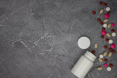 pills and tablets on a black background. top view. copy space.