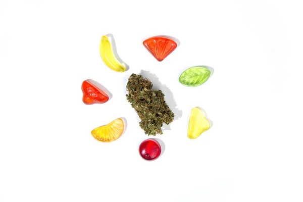 Suchy Pączek Marihuany Leży Białym Tle Otoczony Gumowymi Cukierkami Różnych — Zdjęcie stockowe