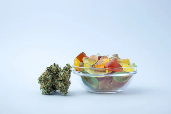 Różne Żelki Małej Szklanej Misce Obok Kilku Pączków Medycznej Marihuany — Zdjęcie stockowe