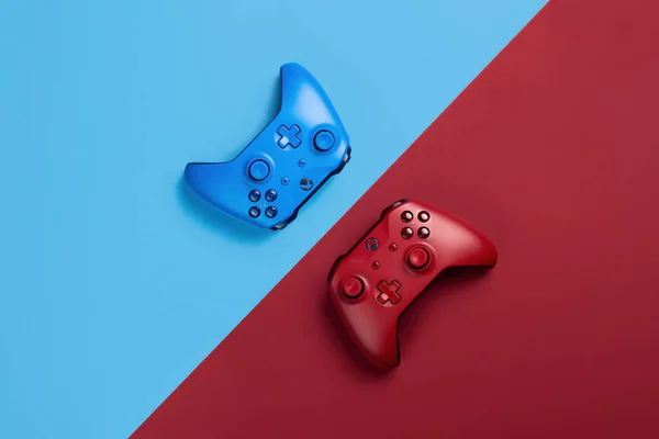 Два Геймпади Xbox Лежать Навпроти Один Одного Синьому Червоному Фоні — стокове фото