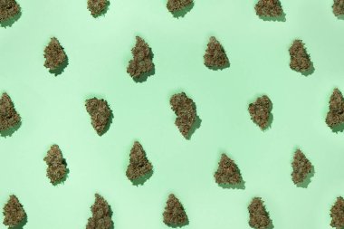 Tıbbî marihuana şablonu, nane arkaplanda, dama tahtası deseninde dizilmiş..