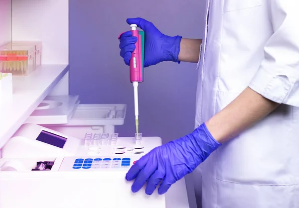 stock image A laboratory assistant (doctor) in a clinical laboratory examines blood for clotting (homeostasis analysis).  Women's hands in gloves