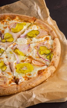 Jambon, soğan ve salatalık turşulu nefis iştah açıcı pizza. Siyah arka planda. Çok fazla peynir var.