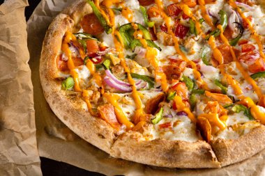 Füme sosisli, yeşil biberli, soğanlı ve soslu nefis iştah açıcı pizza.