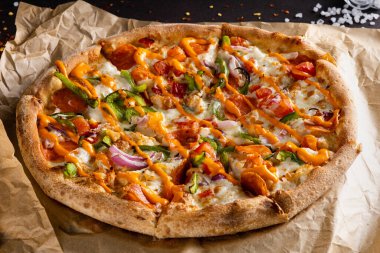 Füme sosisli, yeşil biberli, soğanlı ve soslu nefis iştah açıcı pizza. 