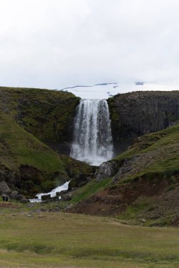 Kerlingarfoss Waterfall near Olafsvik on Icelands Snafellsnes peninsula. High quality photo. Beautiful waterfall with the Snaefellsjokull Volcano in the background.