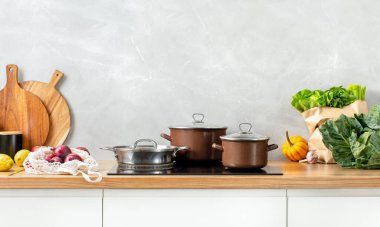 Contemporary kitchen concept or culinary background. Front view of a kitchen counter top with some utensils and culinary ingredients. Huge empty space for a text above.