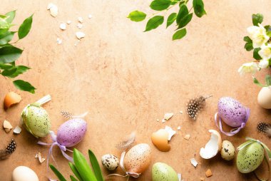 Paskalya arkaplanı bir karşılama metni ve renkli yumurta ve bahar çiçekleri gibi çeşitli Paskalya dekorları için bir kopya alanı ile birlikte.