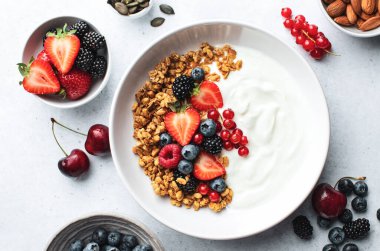 Ev yapımı tahıl gevreği kasesi ve taze yaz meyveleri.