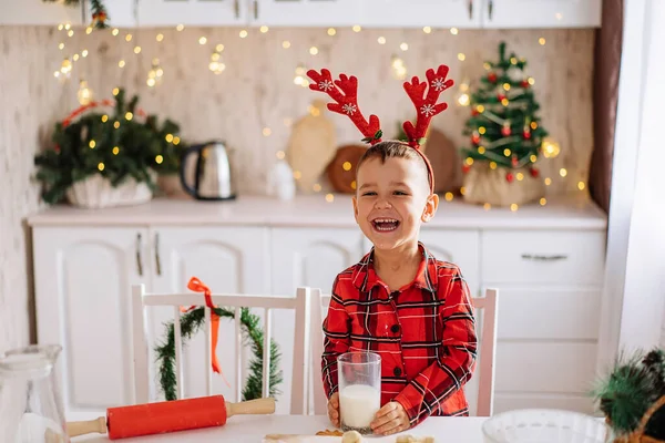 Очаровательный Мальчик Клетчатой Пижаме Молоком Руках Смеется Кухне Украшенный Рождество — стоковое фото
