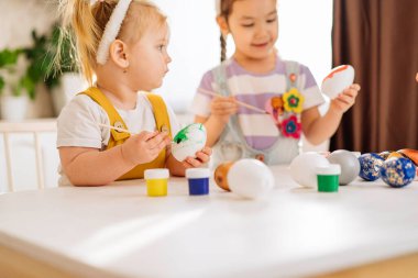 İki çocuk mutfakta paskalya yumurtası çiziyor. Yakın plan. Mutluluk kavramı, çocuklar için Paskalya tatili.