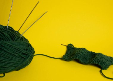 Parlak arkaplanda kısmen örülmüş yeşil iplik.