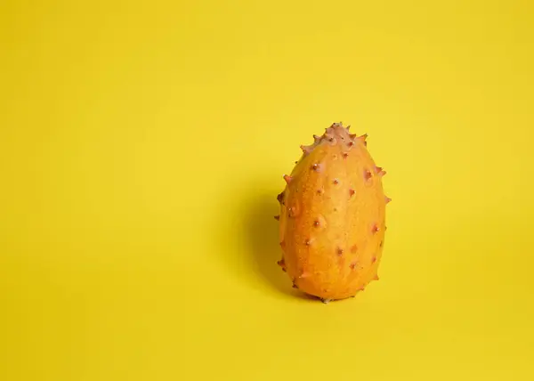 Sarı yüzeyde Kiwano meyvesi.