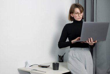 Masada dizüstü bilgisayarla çalışan odaklanmış bir kadın.