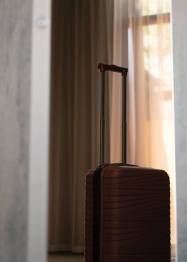 Otel odasında kestane rengi bavul